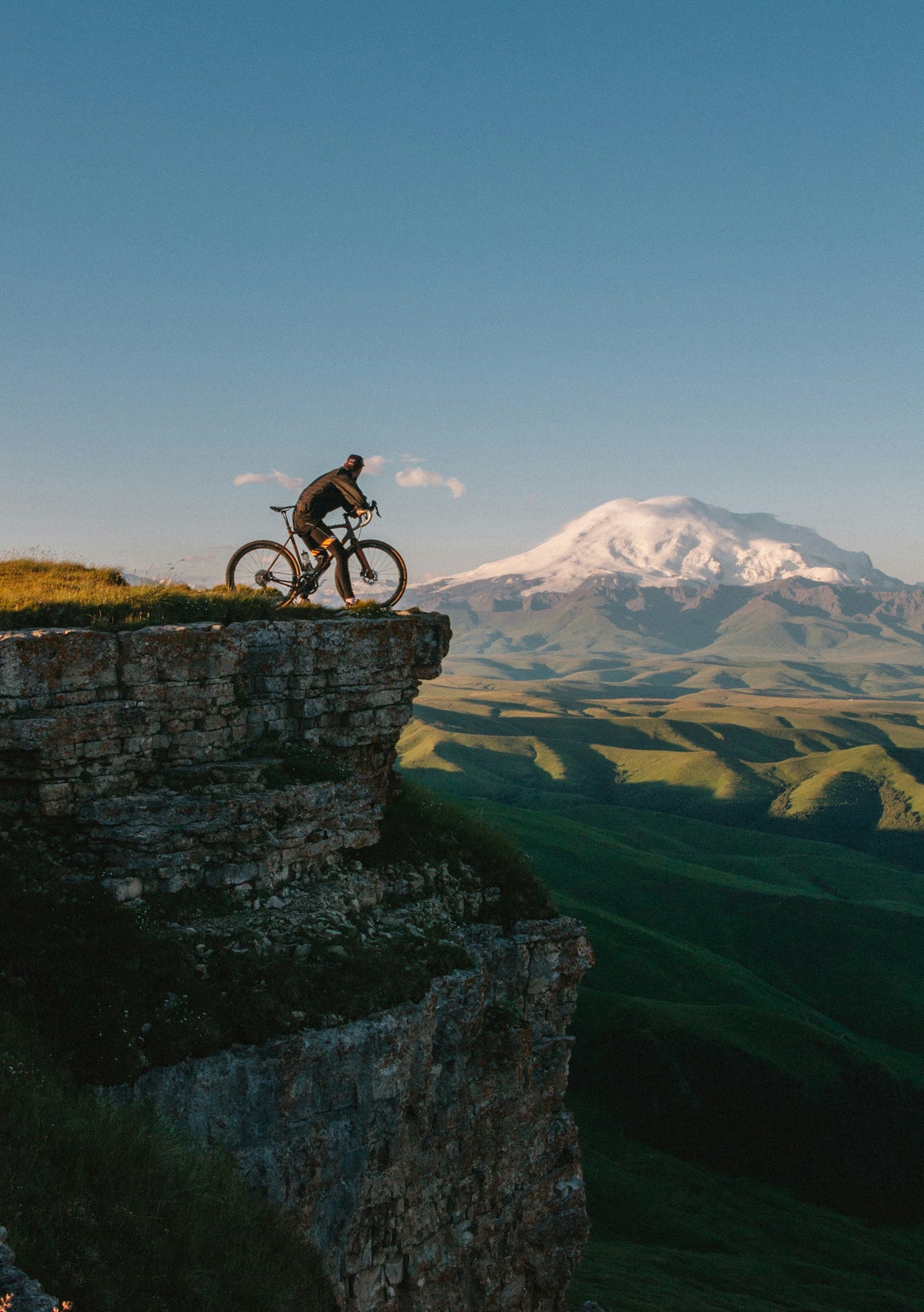 Person on a bicycle at the edge of a cliff with a mountain in the background for Brand Elk Sports Nutrition